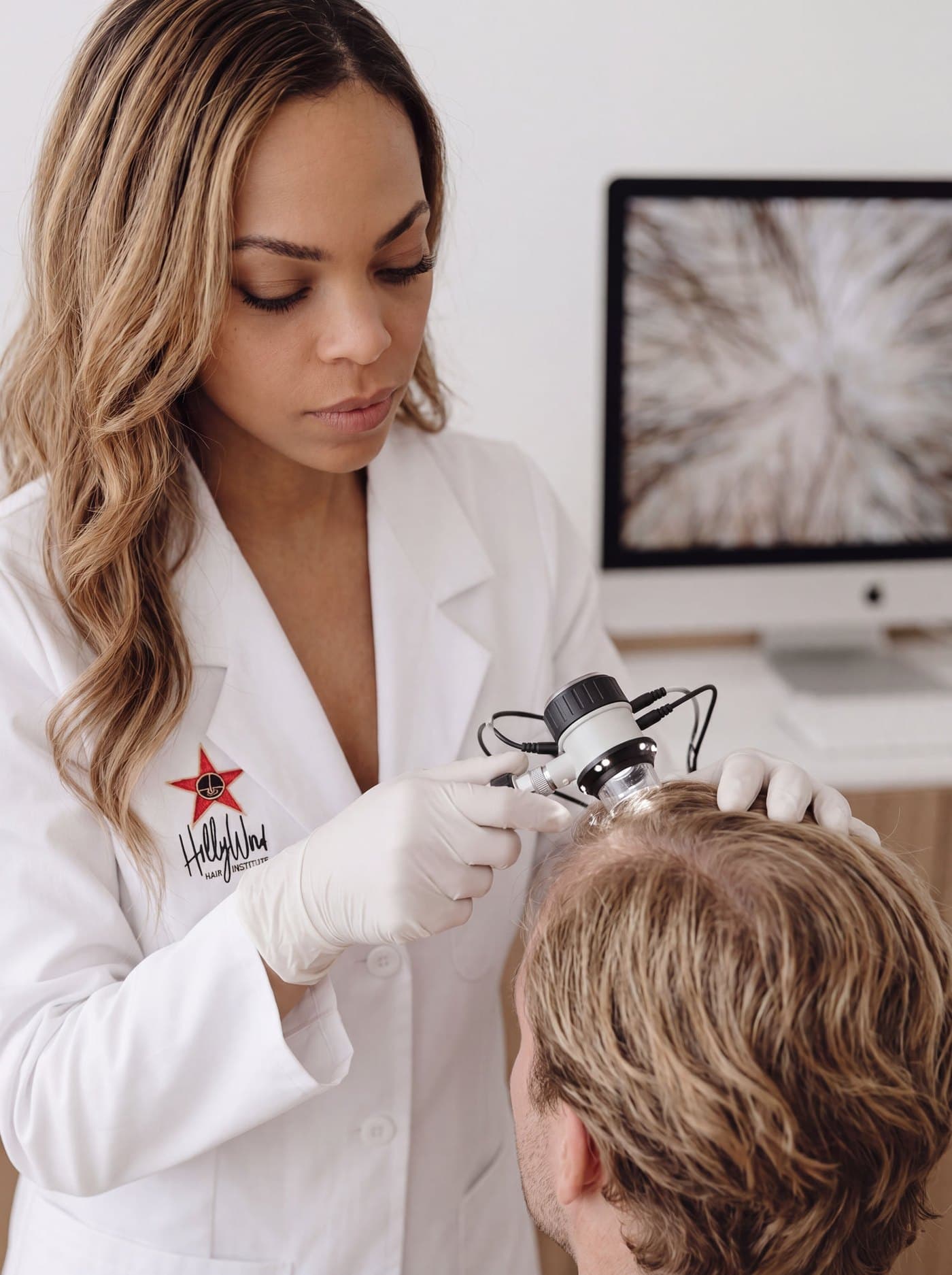 HHI physician using a trichoscope to examine a patient's scalp
