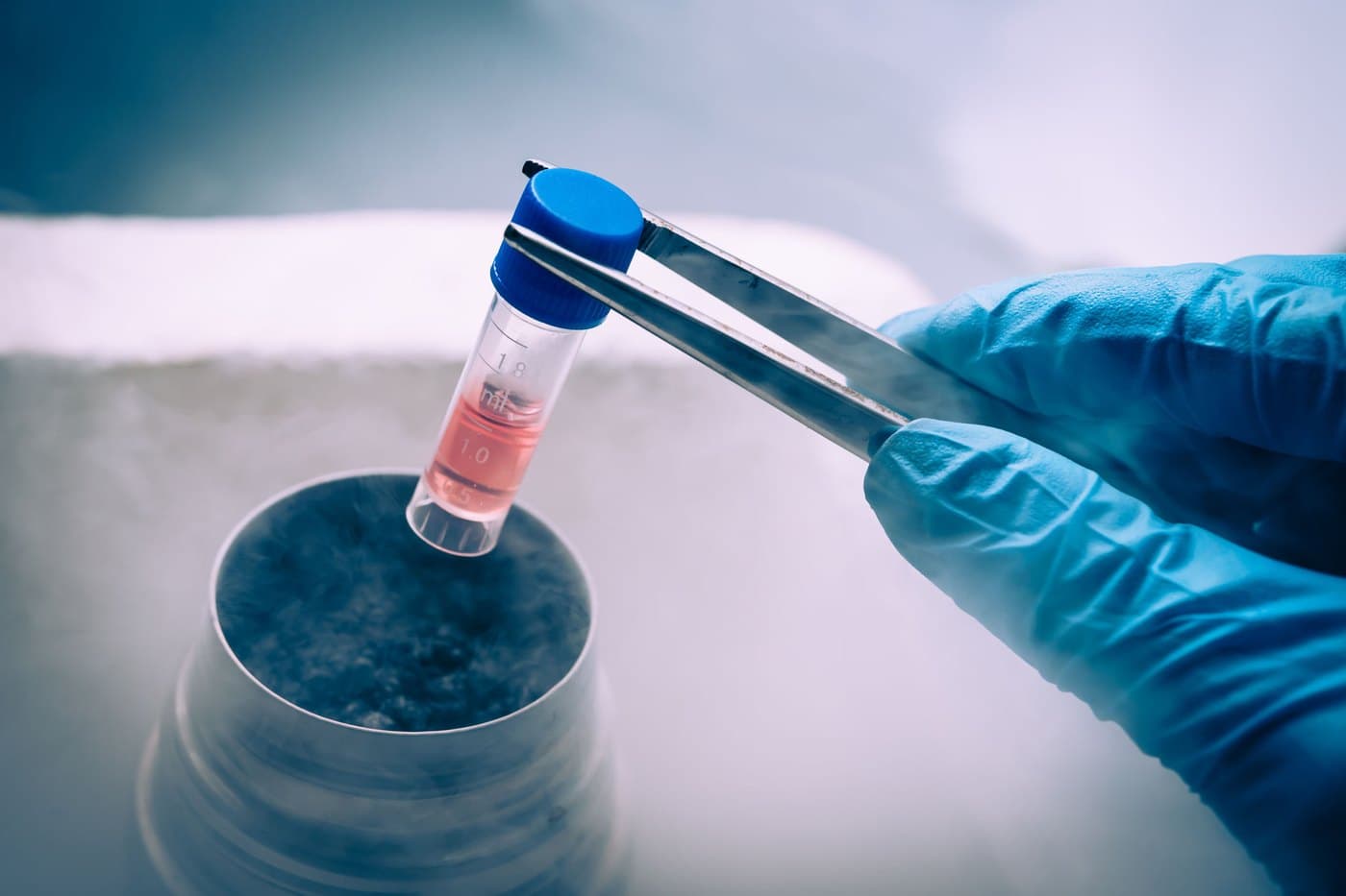 A cryogenic vial being lifted from liquid nitrogen storage, representing regenerative cell-based therapy